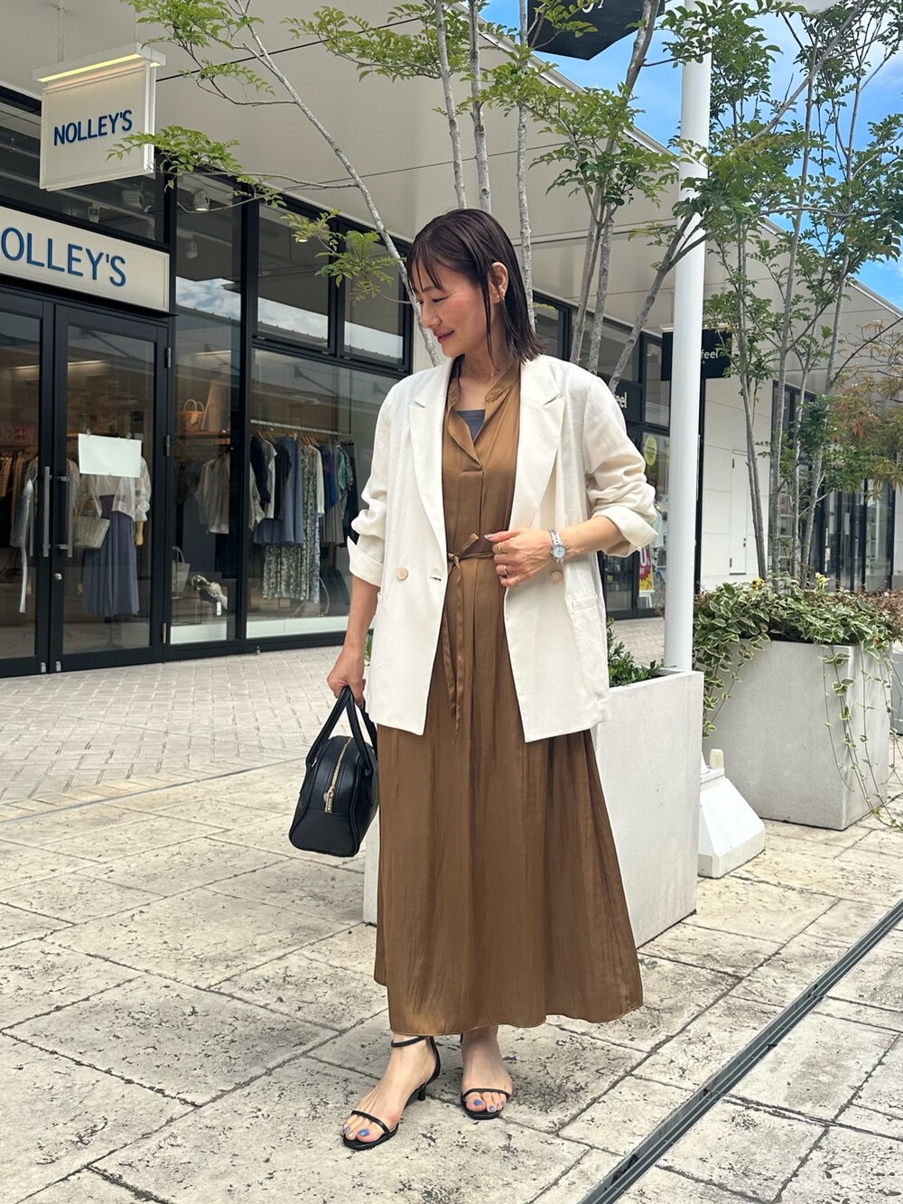 ブラウン系のワンピース、グレー系のTシャツ/カットソー、ホワイト系のテーラードジャケットを着用したレディースの夏コーディネートの4枚目の写真