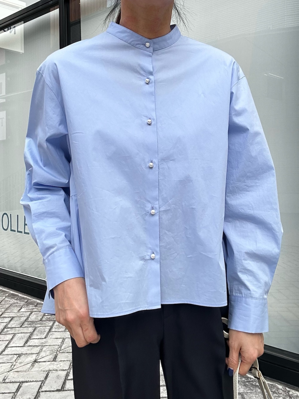 ホワイト系のショルダーバッグ、ベージュ系のブルゾン、ブルー系のテーラードジャケットを着用したレディースの春コーディネートの4枚目の写真