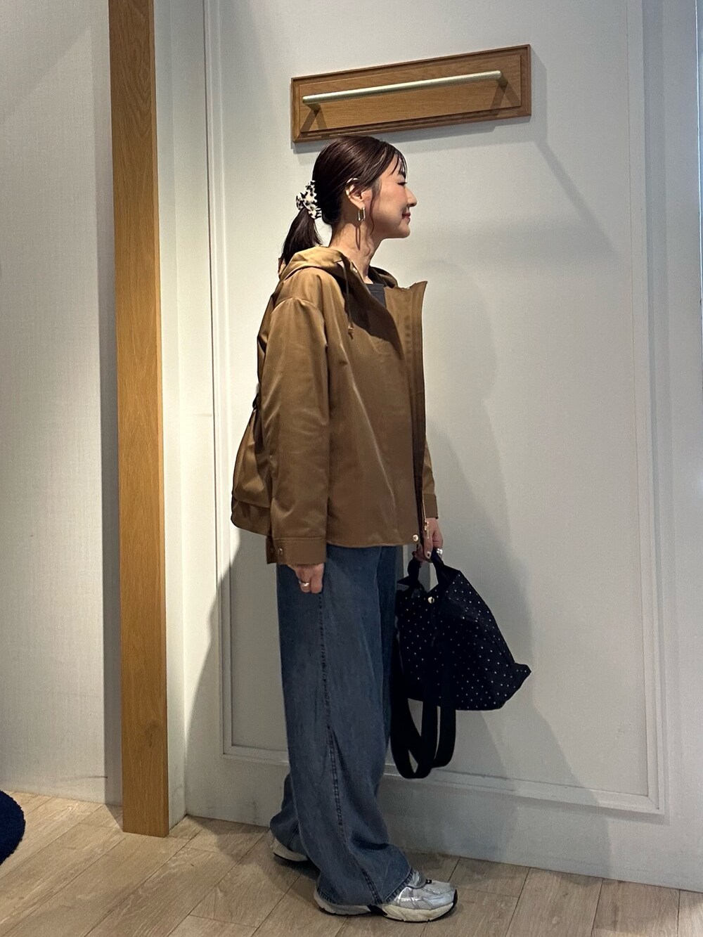 グレー系のTシャツ/カットソー、ブルー系のデニムパンツ、ブラウン系のブルゾンを着用したレディースの秋コーディネートの4枚目の写真