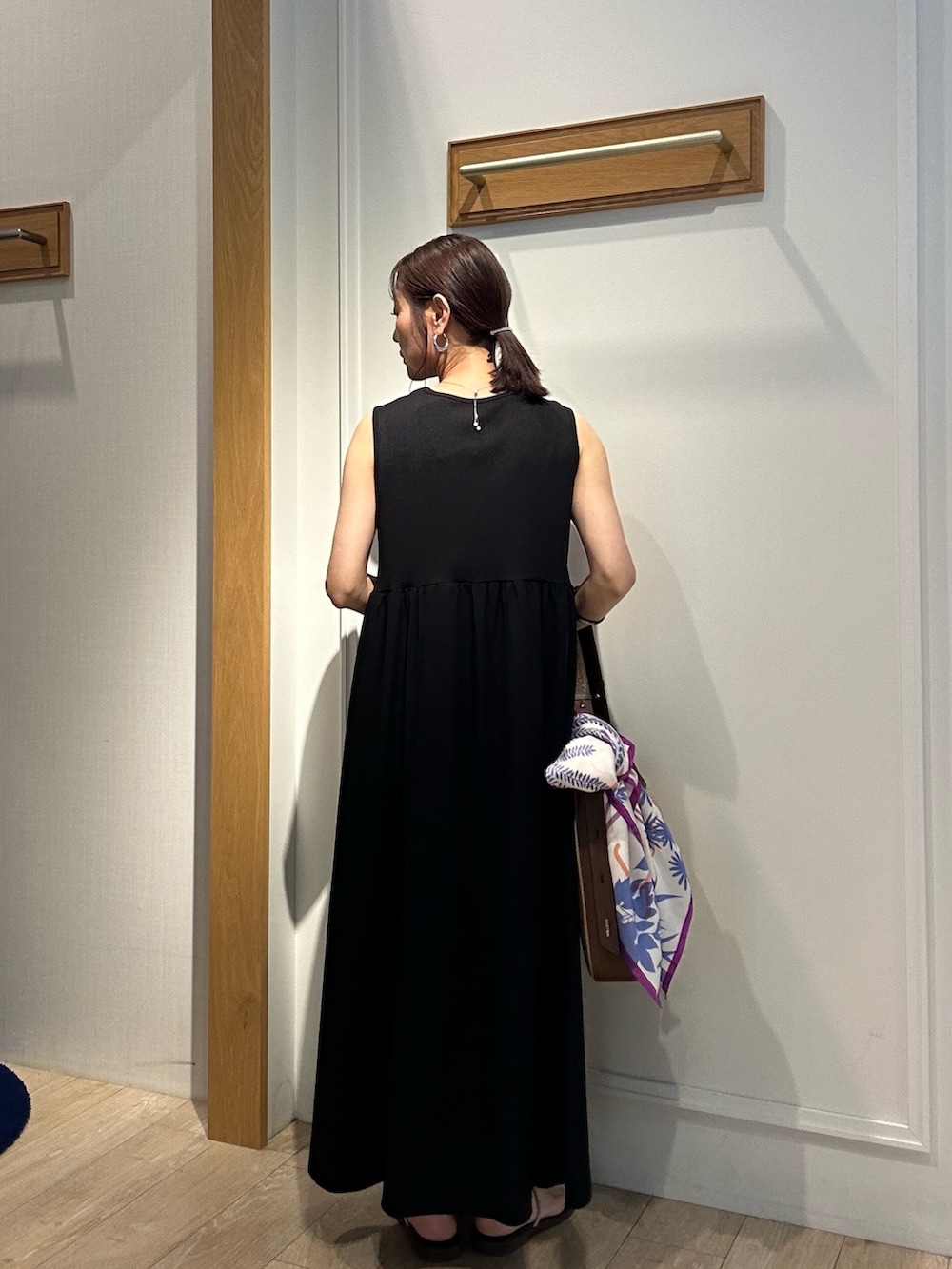 ホワイト系のニット/セーター、ブラック系のワンピース、ブラック系のサンダルを着用したレディースの夏コーディネートの10枚目の写真