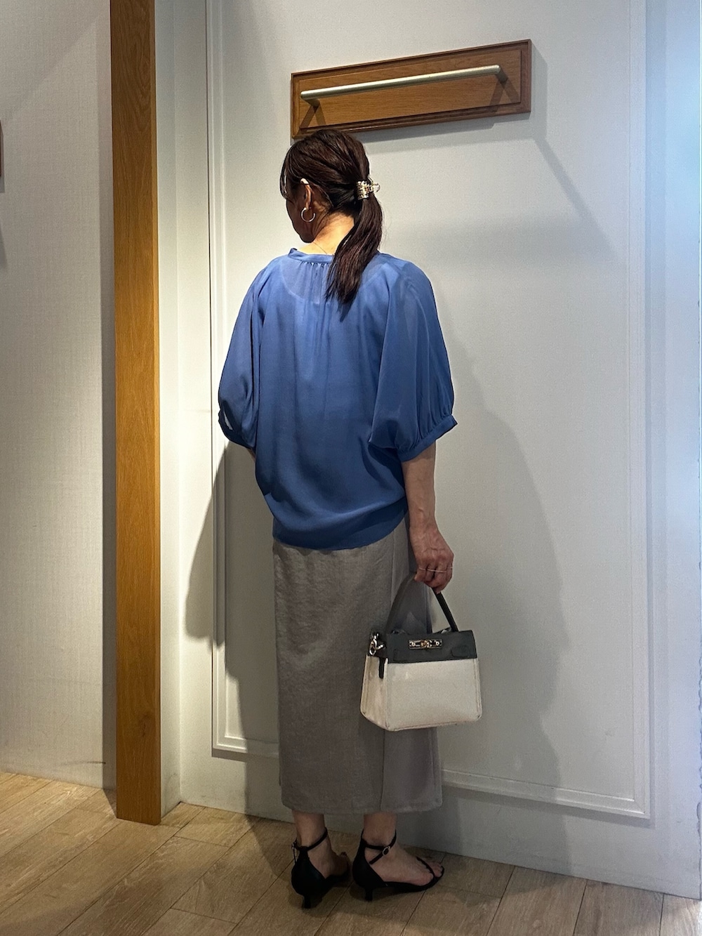 ブルー系のシャツ/ブラウス、ホワイト系のTシャツ/カットソー、グレー系のスカートを着用したレディースの夏コーディネートの4枚目の写真