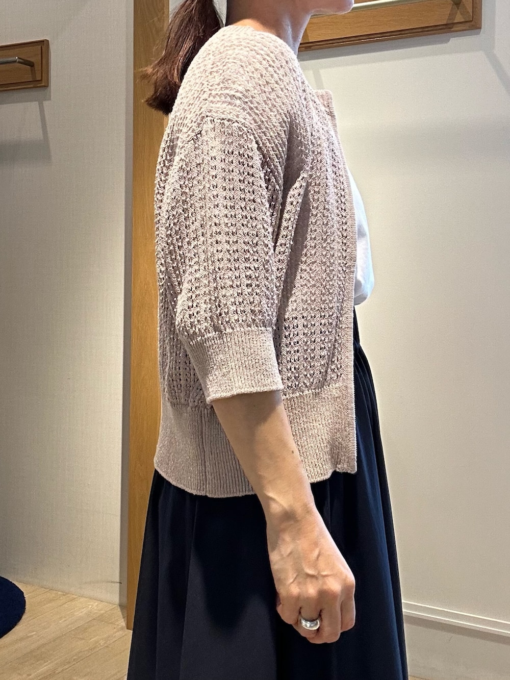 ベージュ系のニット/セーター、ホワイト系のTシャツ/カットソー、ブルー系のスカートを着用したレディースの春コーディネートの5枚目の写真