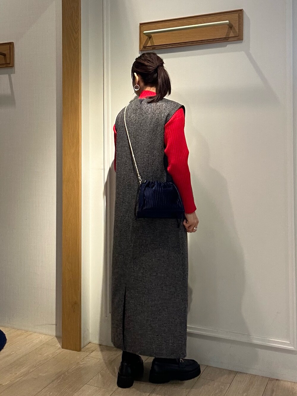グレー系のワンピース、レッド系のニット/セーターを着用したレディースの秋コーディネートの3枚目の写真