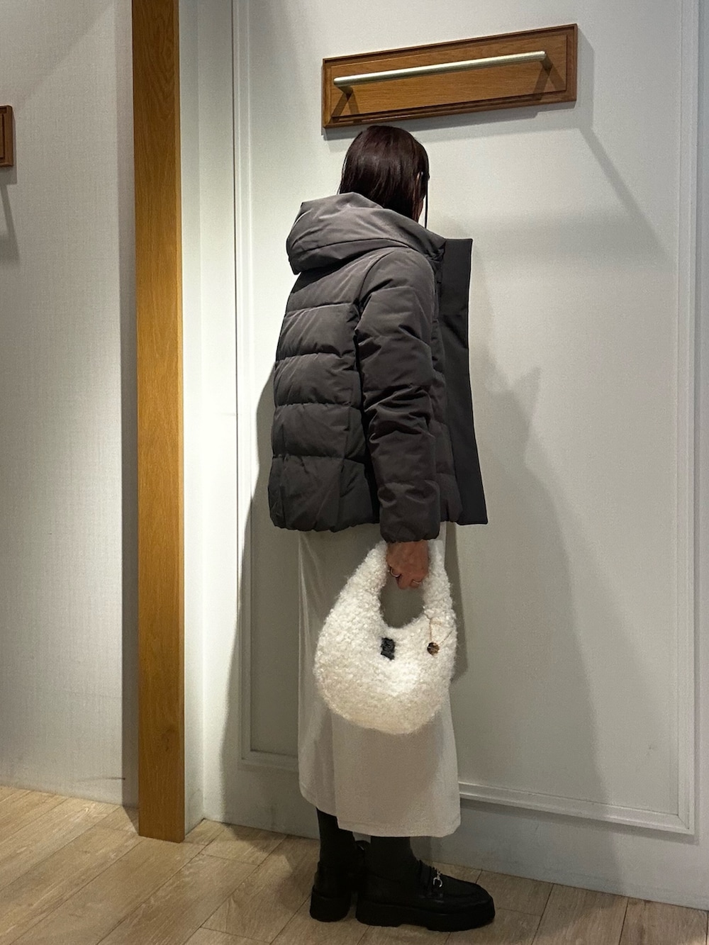 グレー系のダウンジャケット/コート、ピンク系のニット/セーター、ホワイト系のスカートを着用したレディースの冬コーディネートの4枚目の写真