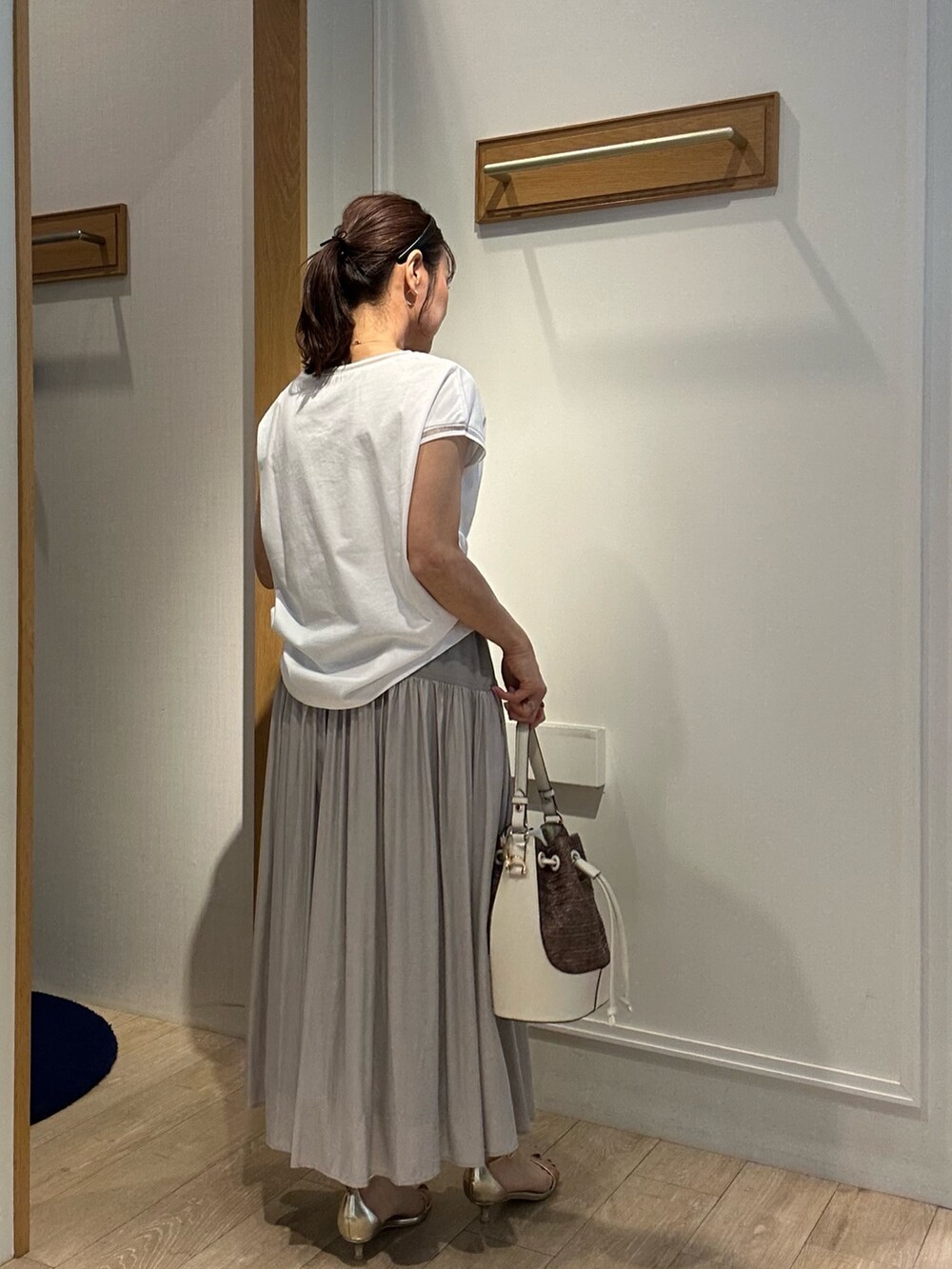 ホワイト系のTシャツ/カットソー、ベージュ系のスカート、ホワイト系のブルゾンを着用したレディースの春コーディネートの2枚目の写真