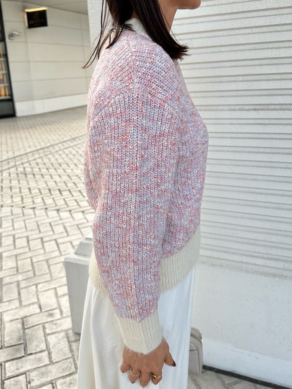 ピンク系のニット/セーター、ホワイト系のスカート、ホワイト系のボストンバッグを着用したレディースの冬コーディネートの6枚目の写真