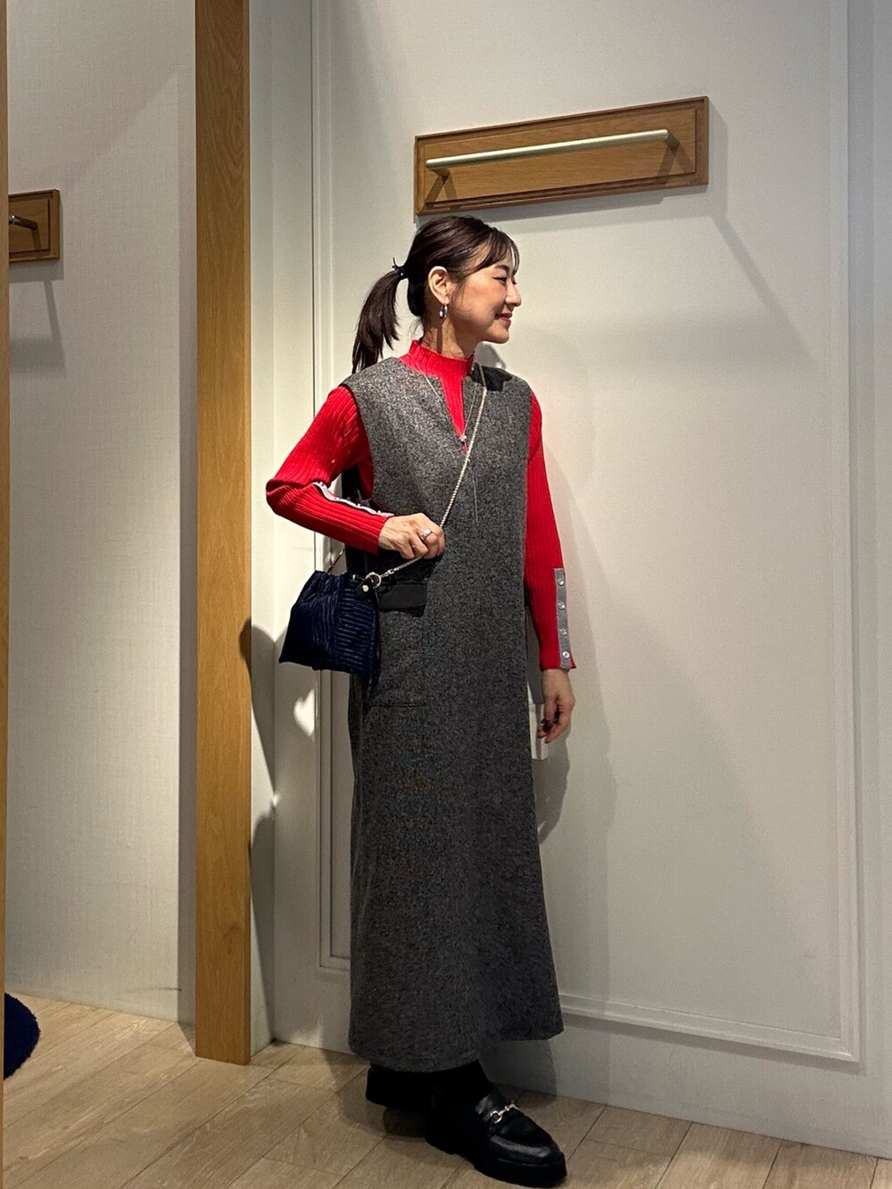 グレー系のワンピース、レッド系のニット/セーターを着用したレディースの秋コーディネートの5枚目の写真