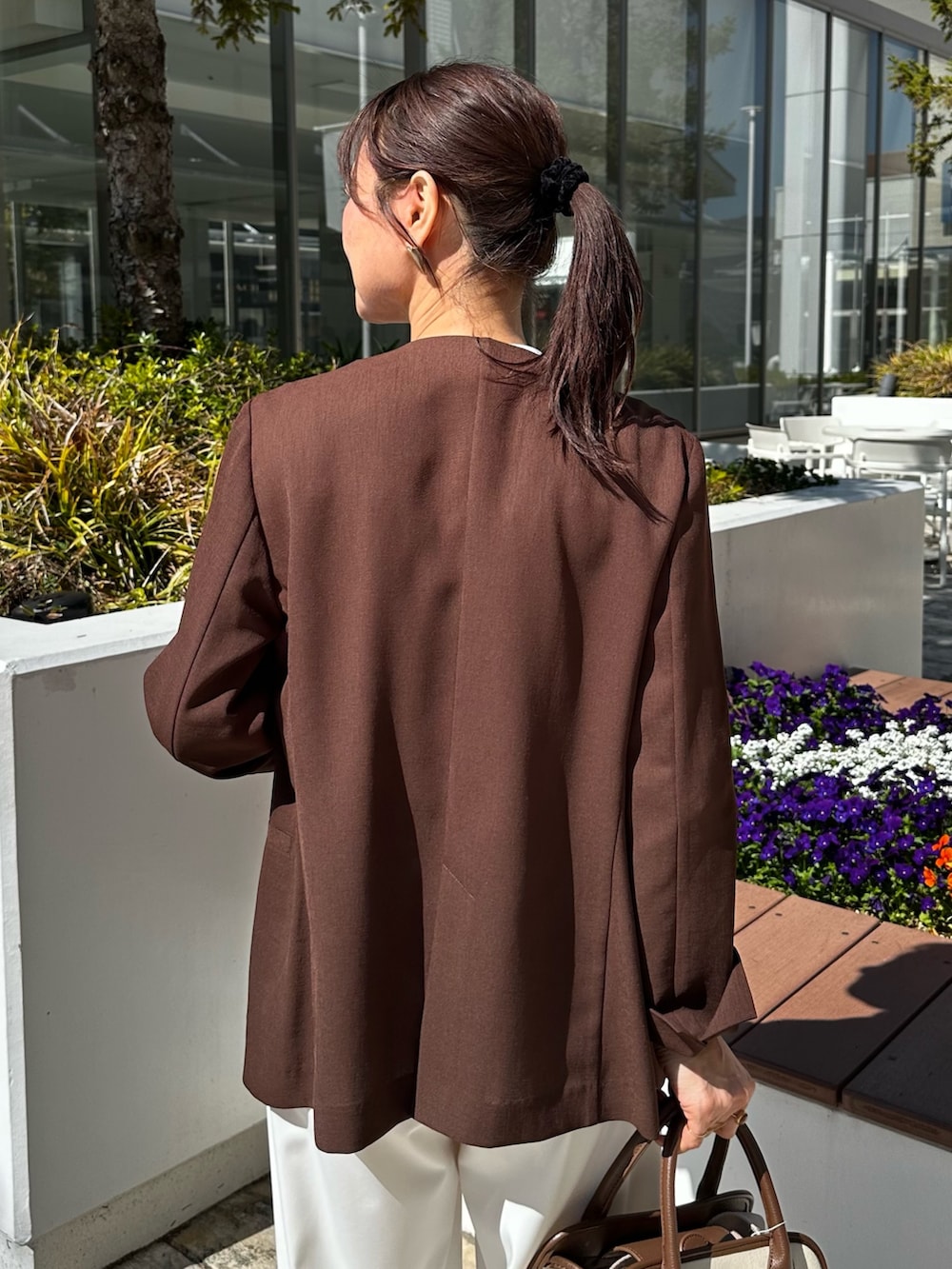 ブラウン系のノーカラージャケット、ブルー系のシャツ/ブラウス、ホワイト系のその他パンツを着用したレディースの春コーディネートの7枚目の写真