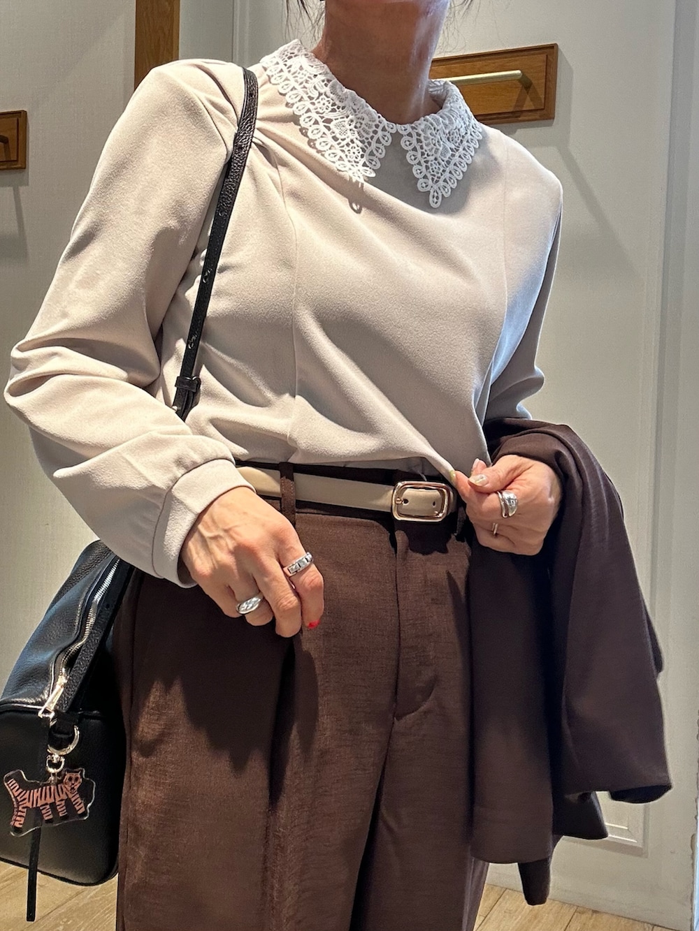 ブラック系のショルダーバッグ、ベージュ系のシャツ/ブラウス、ブラウン系のノーカラージャケットを着用したレディースの春コーディネートの7枚目の写真