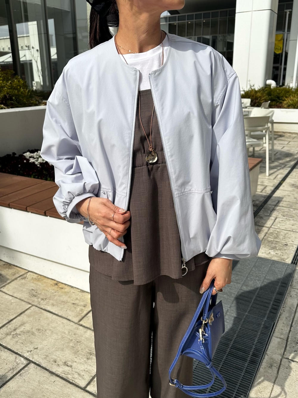 ブルー系のブルゾン、グリーン系のシャツ/ブラウス、ブルー系のショルダーバッグを着用したレディースの春コーディネートの4枚目の写真