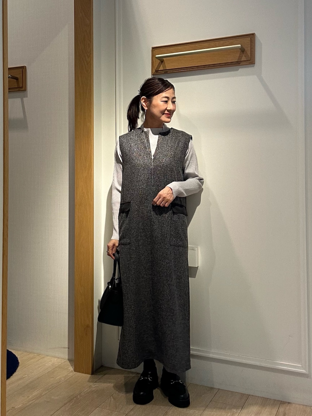 グレー系のワンピース、ブラック系のトートバッグを着用したレディースの秋コーディネートの4枚目の写真