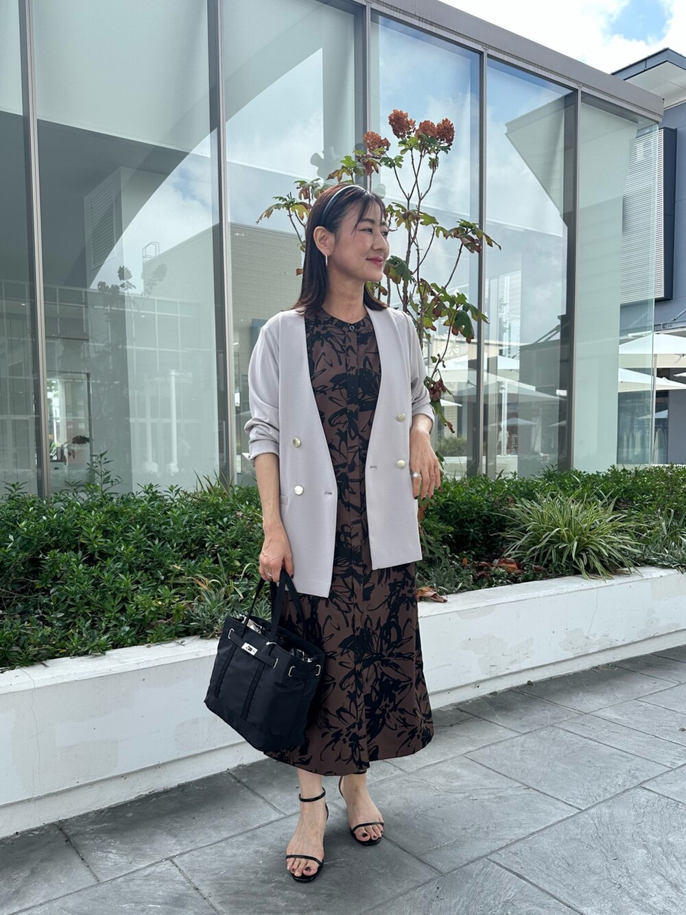 ホワイト系のワンピース、ブラック系のトートバッグを着用したレディースの秋コーディネートの4枚目の写真