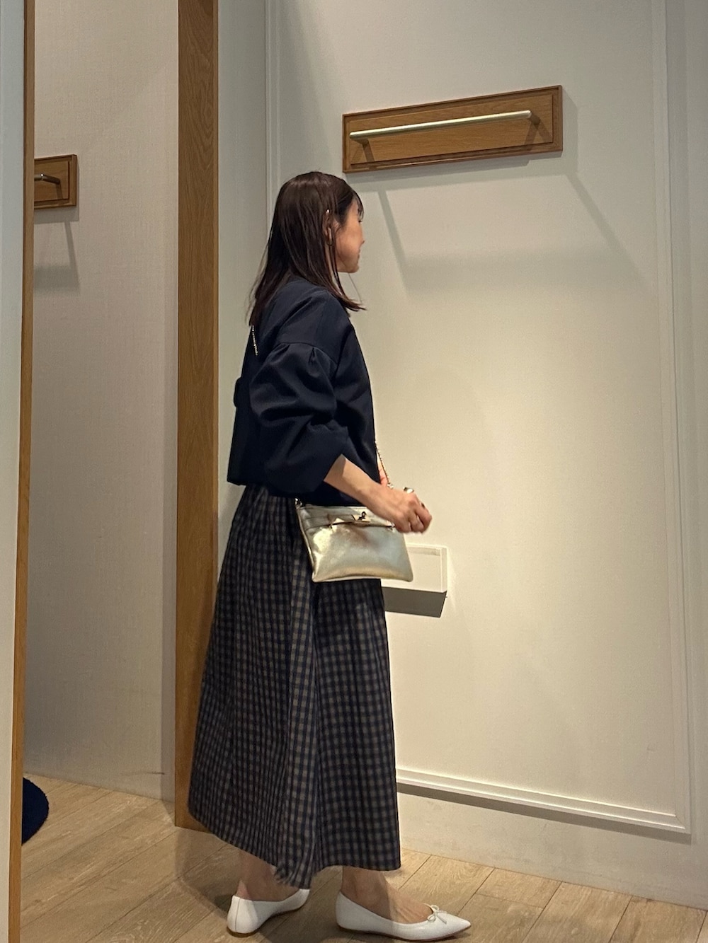 ブルー系のノーカラージャケット、ホワイト系のTシャツ/カットソー、ブラウン系のスカートを着用したレディースの冬コーディネートの3枚目の写真