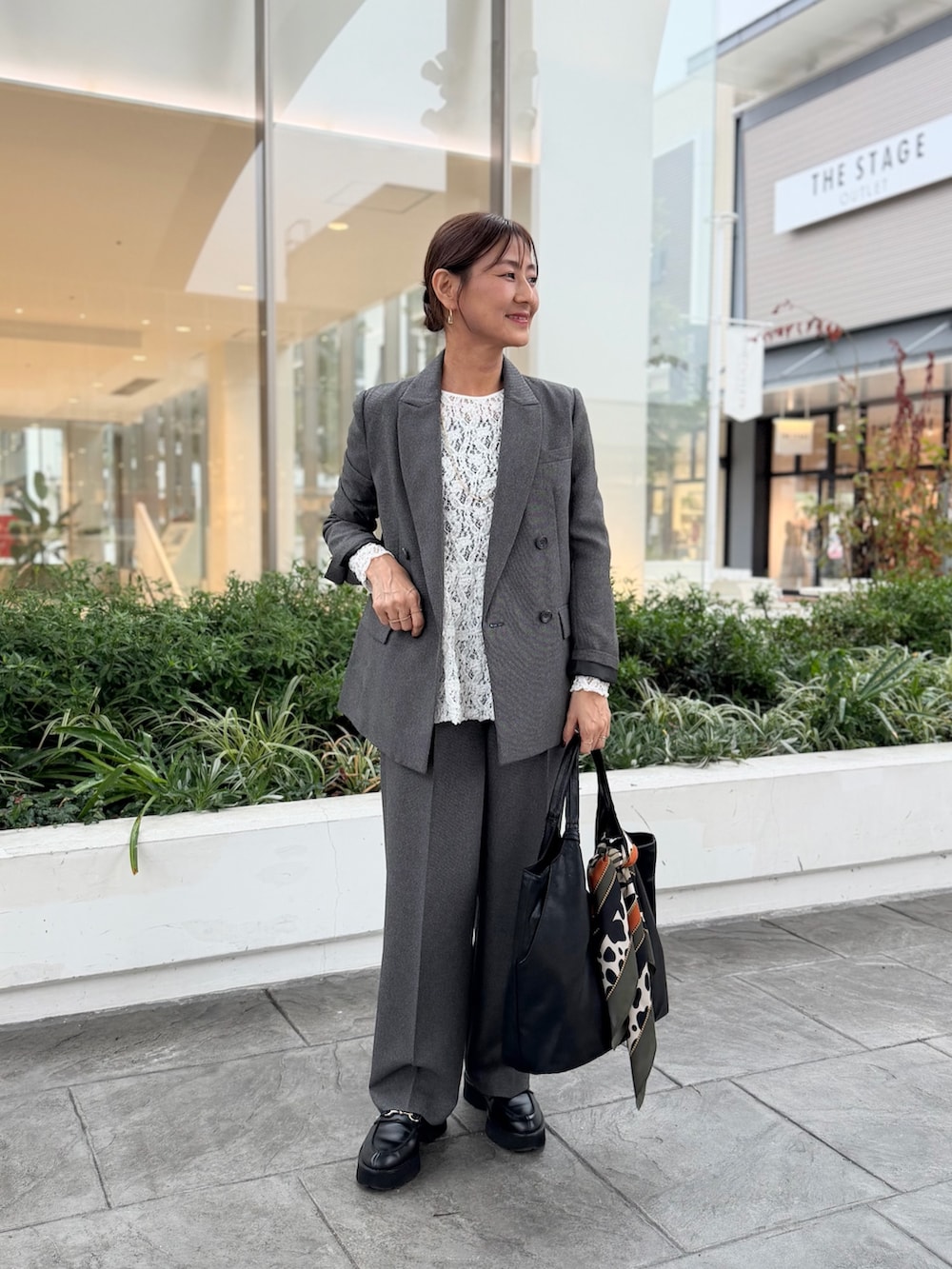 ブラック系のその他パンツ、ブラック系のトートバッグ、グレー系のTシャツ/カットソーを着用したレディースの秋コーディネートの7枚目の写真