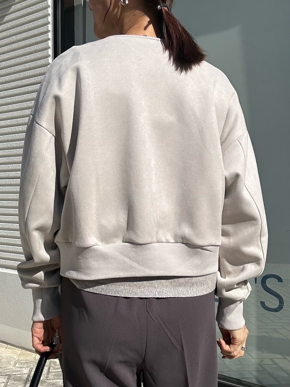 グレー系のその他パンツ、グレー系のニット/セーター、ベージュ系のブルゾンを着用したレディースの秋コーディネートの7枚目の写真