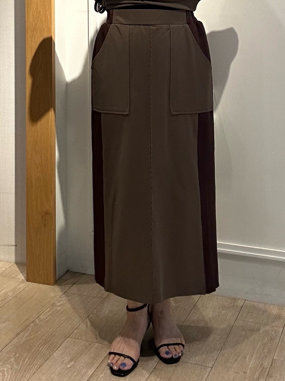 ブラウン系のTシャツ/カットソー、ブラウン系のスカート、ブラック系のサンダルを着用したレディースの夏コーディネートの8枚目の写真