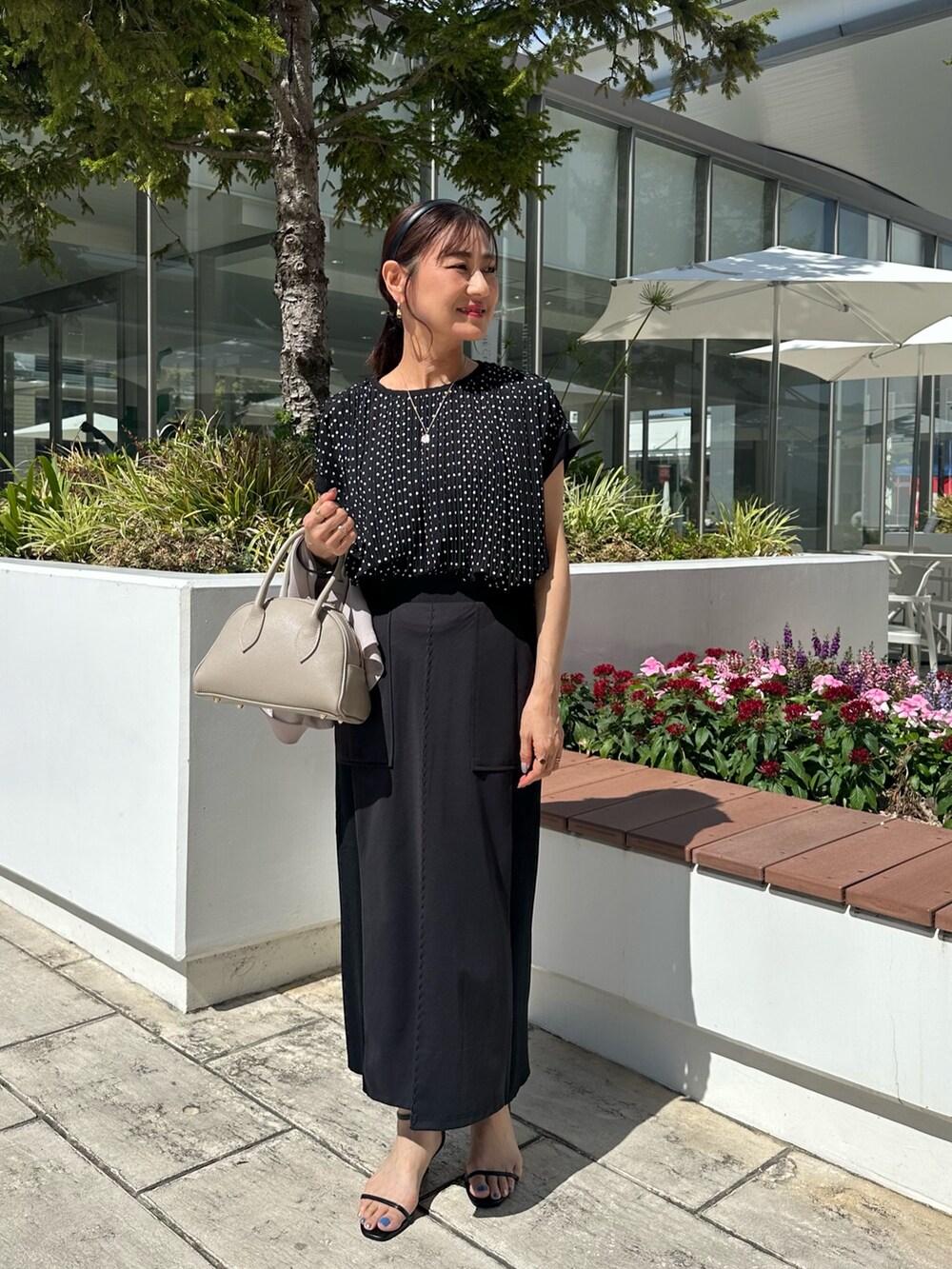 ベージュ系のテーラードジャケット、ブラック系のシャツ/ブラウス、ベージュ系のボストンバッグを着用したレディースの夏コーディネートの7枚目の写真