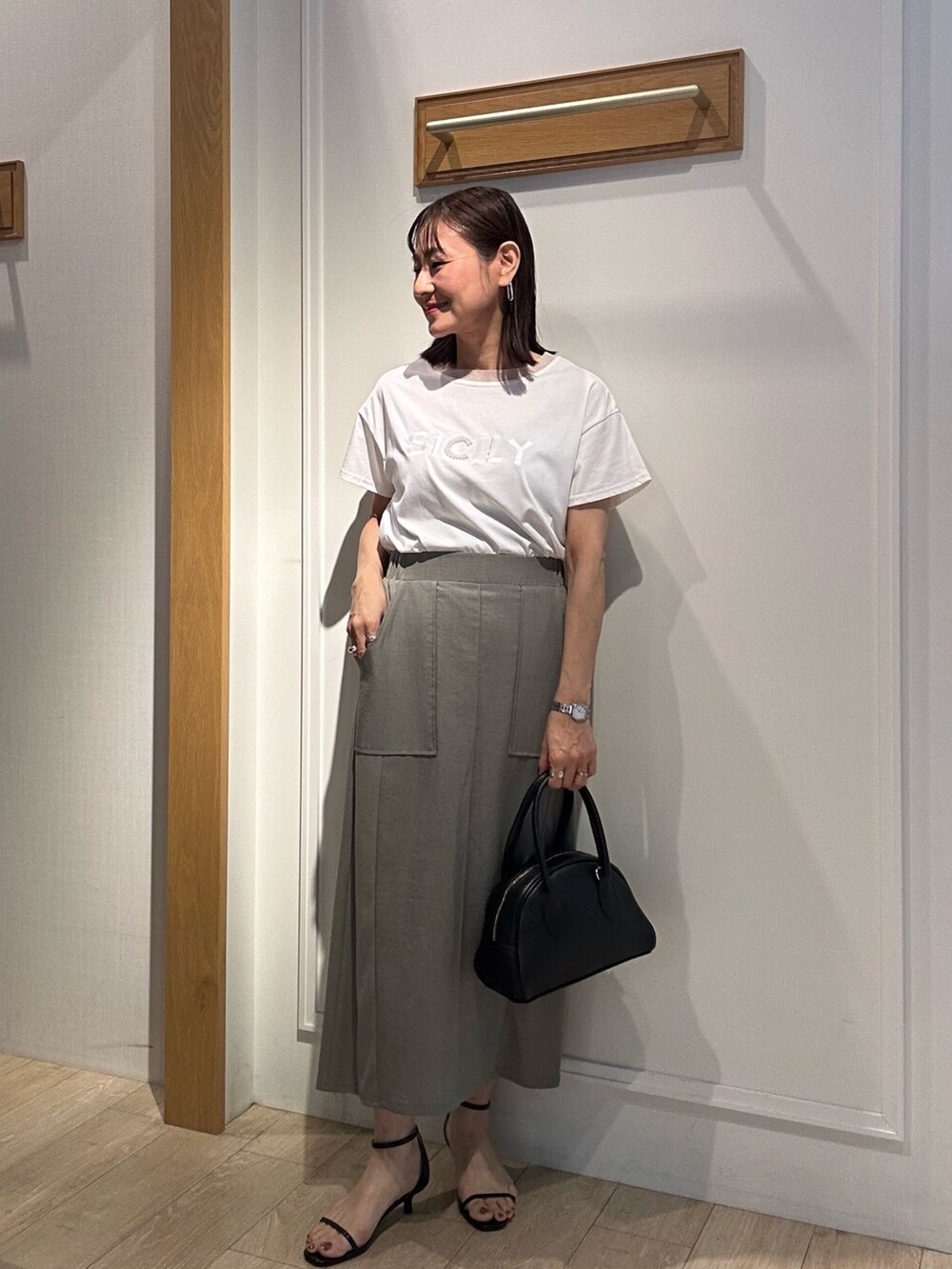 グレー系のテーラードジャケット、ホワイト系のTシャツ/カットソー、グリーン系のスカートを着用したレディースの夏コーディネートの10枚目の写真