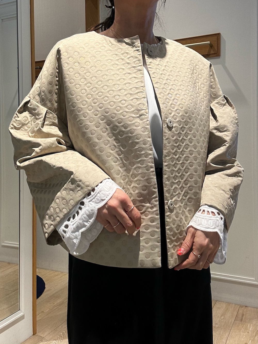 ホワイト系のショルダーバッグ、ホワイト系のシャツ/ブラウス、ベージュ系のブルゾンを着用したレディースの冬コーディネートの4枚目の写真