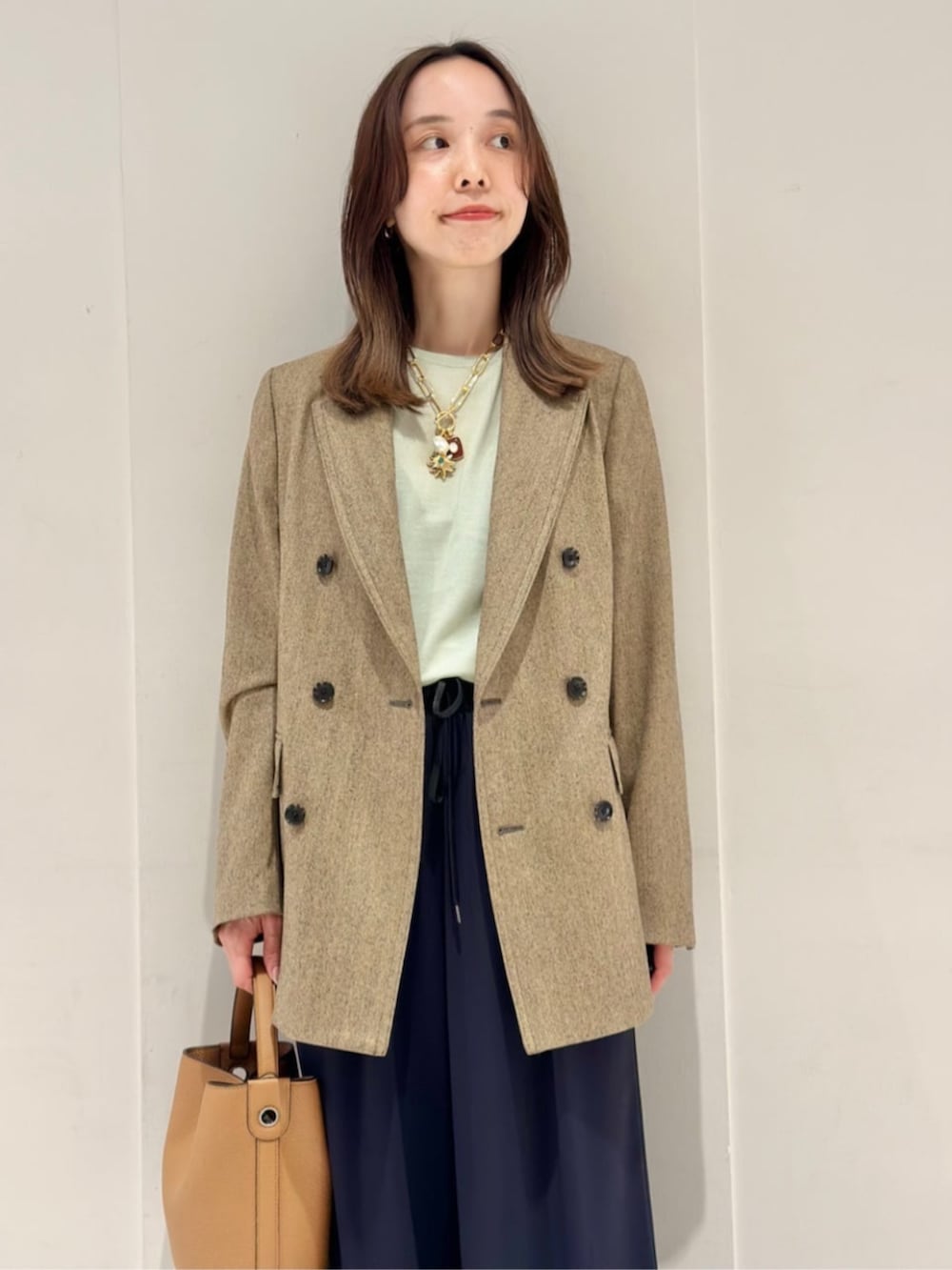 ブルー系のその他パンツ、ブルー系のパンプス、ベージュ系のテーラードジャケットを着用したレディースの秋コーディネートの4枚目の写真