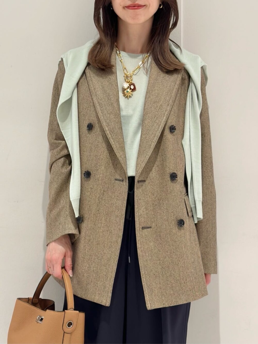 ブルー系のその他パンツ、ブルー系のパンプス、ベージュ系のテーラードジャケットを着用したレディースの秋コーディネートの5枚目の写真