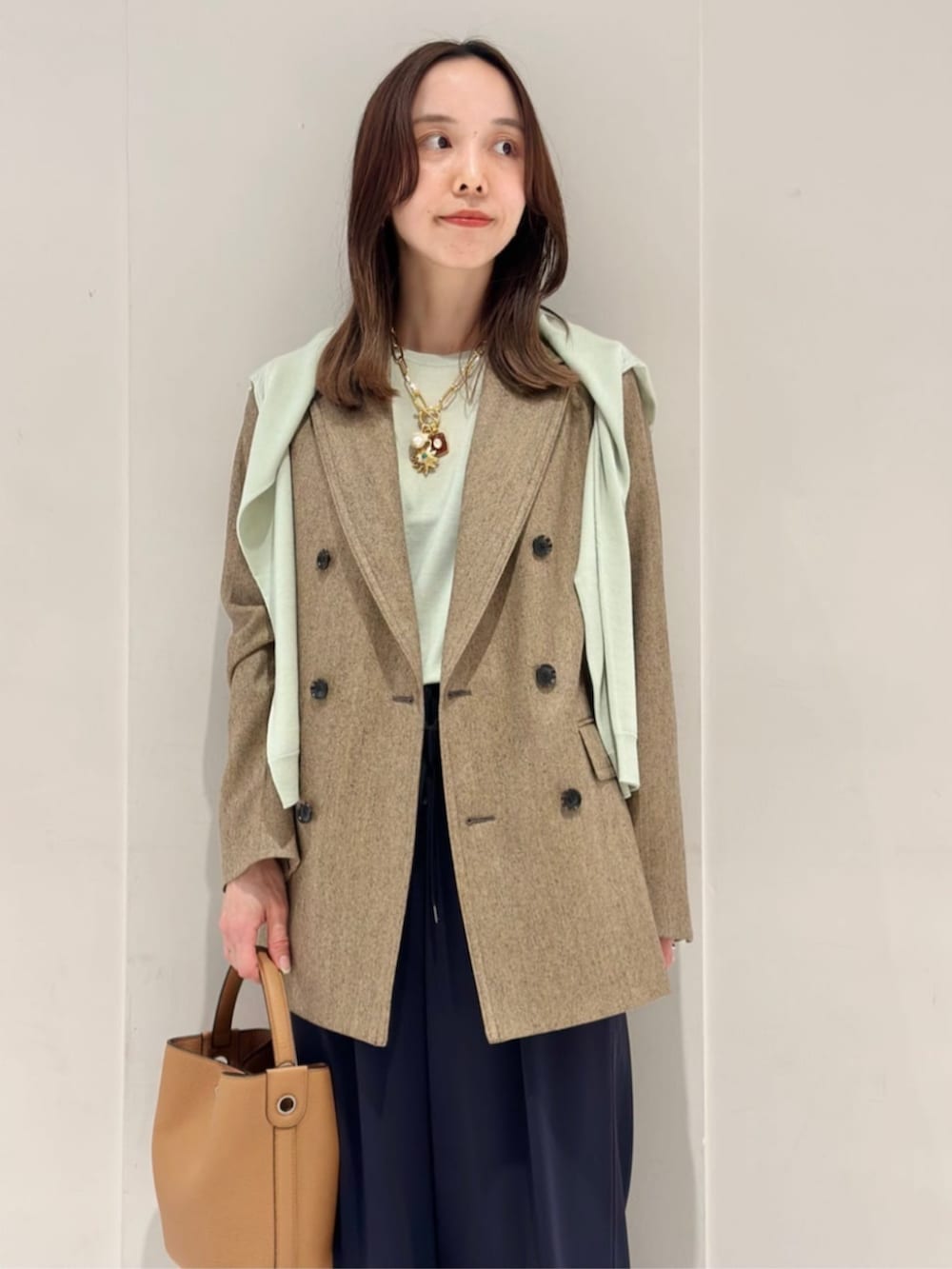 ブルー系のその他パンツ、ブルー系のパンプス、ベージュ系のテーラードジャケットを着用したレディースの秋コーディネートの3枚目の写真
