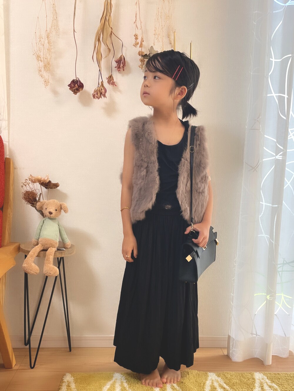 グレー系のベスト、ブラック系のスカート、ブラウン系のベストを着用したキッズの秋コーディネートの3枚目の写真