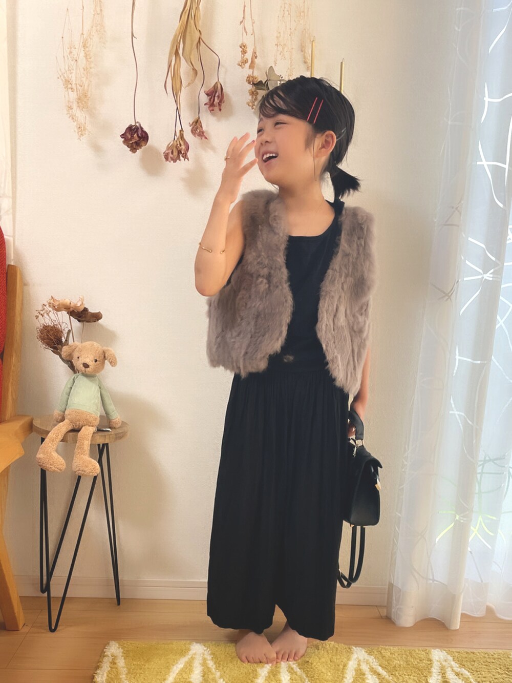 グレー系のベスト、ブラック系のスカート、ブラウン系のベストを着用したキッズの秋コーディネートの4枚目の写真