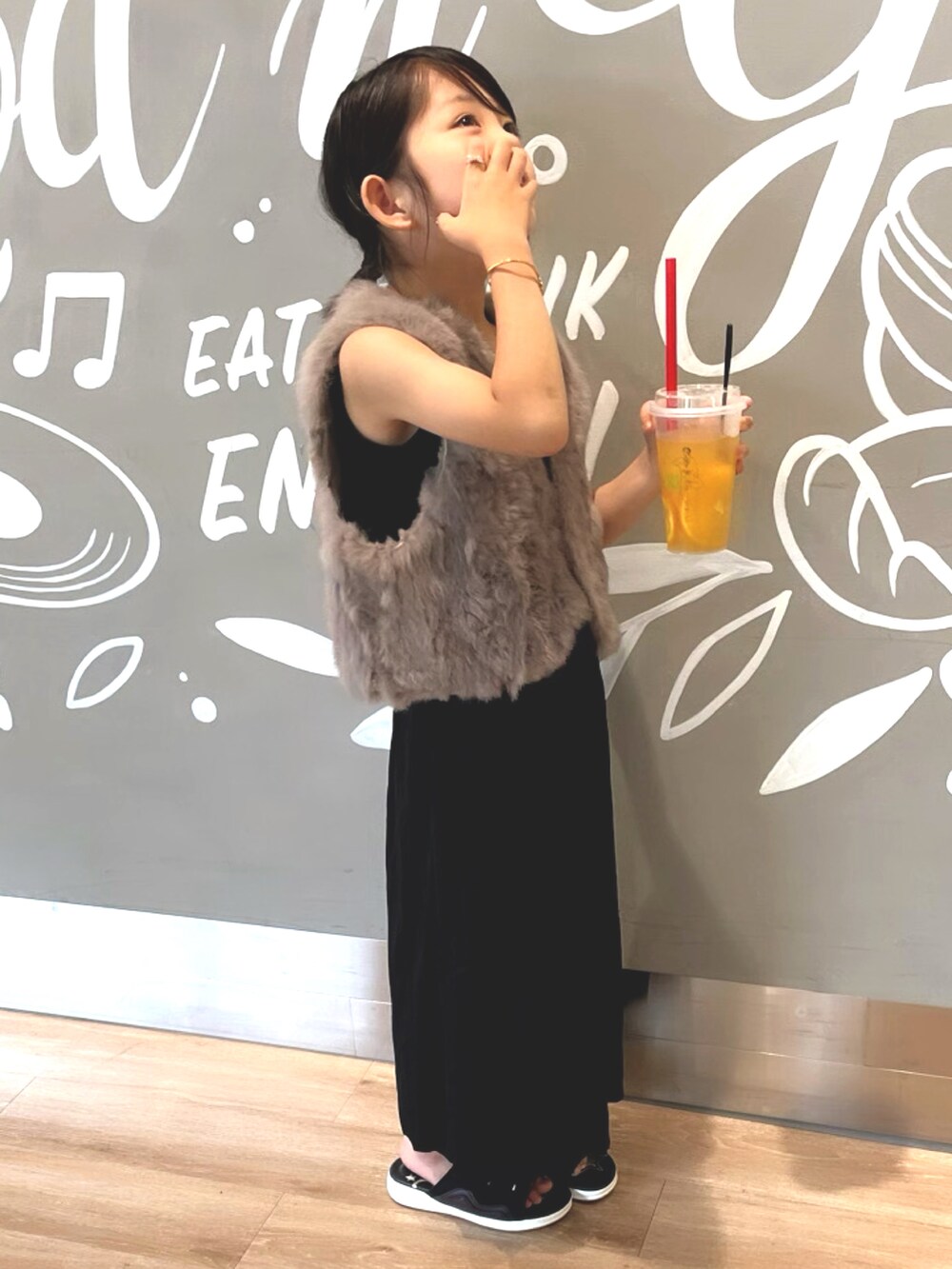 グレー系のベスト、ブラック系のスカート、ブラウン系のベストを着用したキッズの秋コーディネートの2枚目の写真