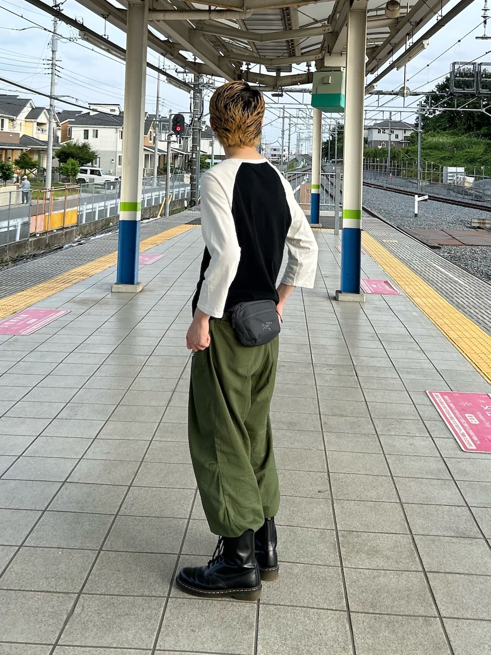 グリーン系のその他パンツ、ブラック系のブーツ、ホワイト系のTシャツ/カットソーを着用したメンズの春コーディネートの2枚目の写真