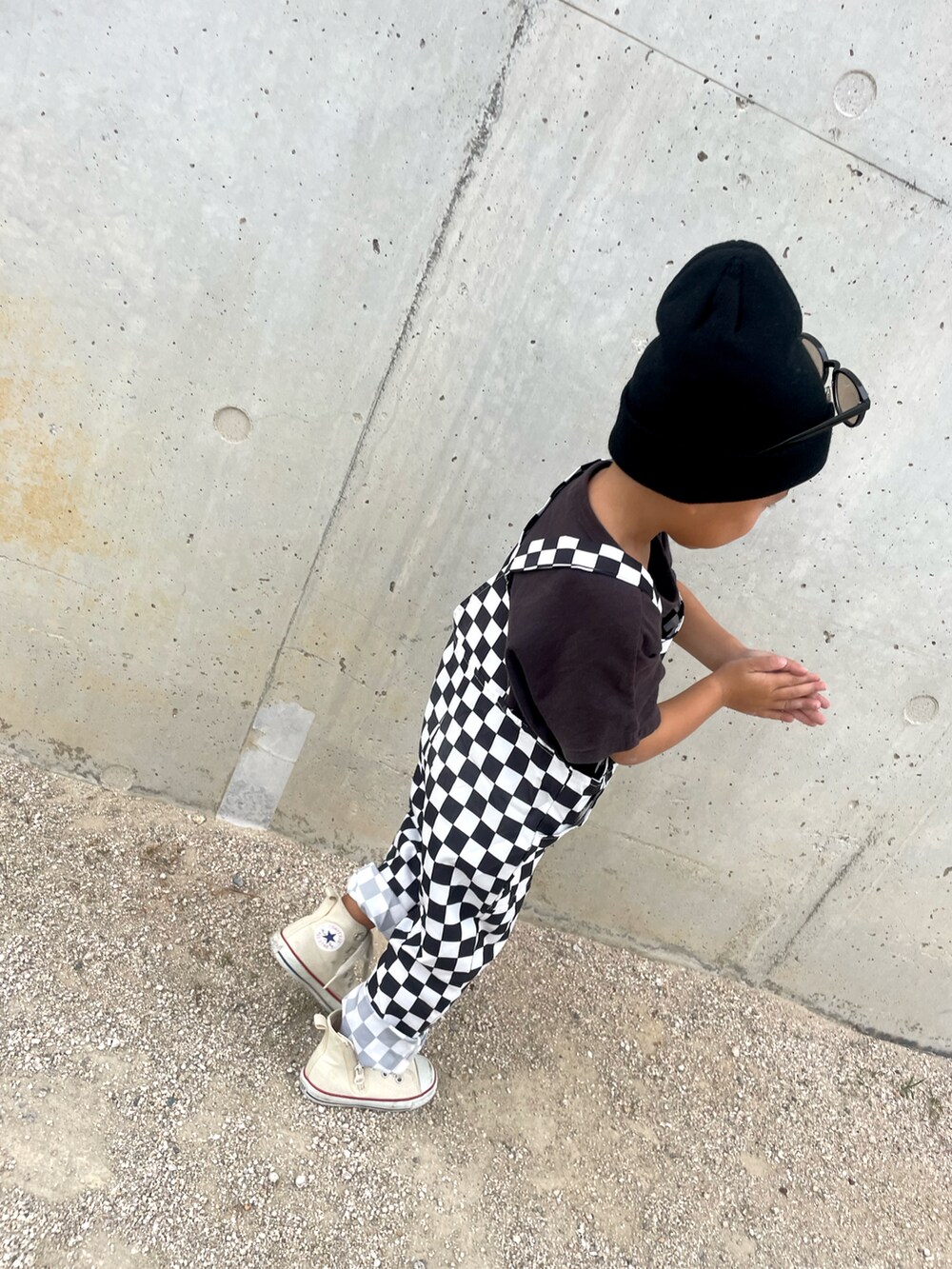 ホワイト系のオールインワン・サロペット、ブラック系のトップス、ホワイト系のスニーカーを着用したキッズの秋コーディネートの3枚目の写真