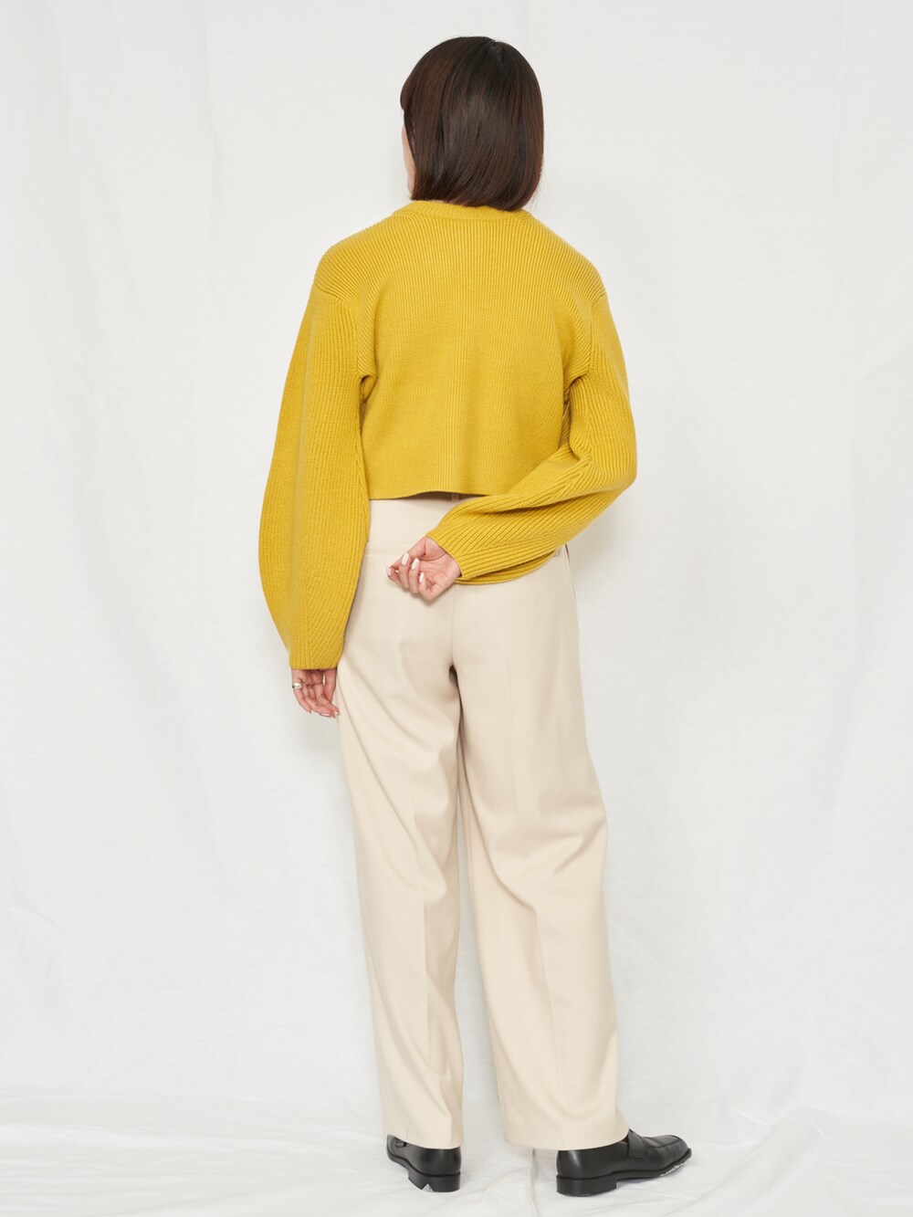 ブラック系のスラックス、イエロー系のカーディガン/ボレロを着用したレディースの秋コーディネートの3枚目の写真