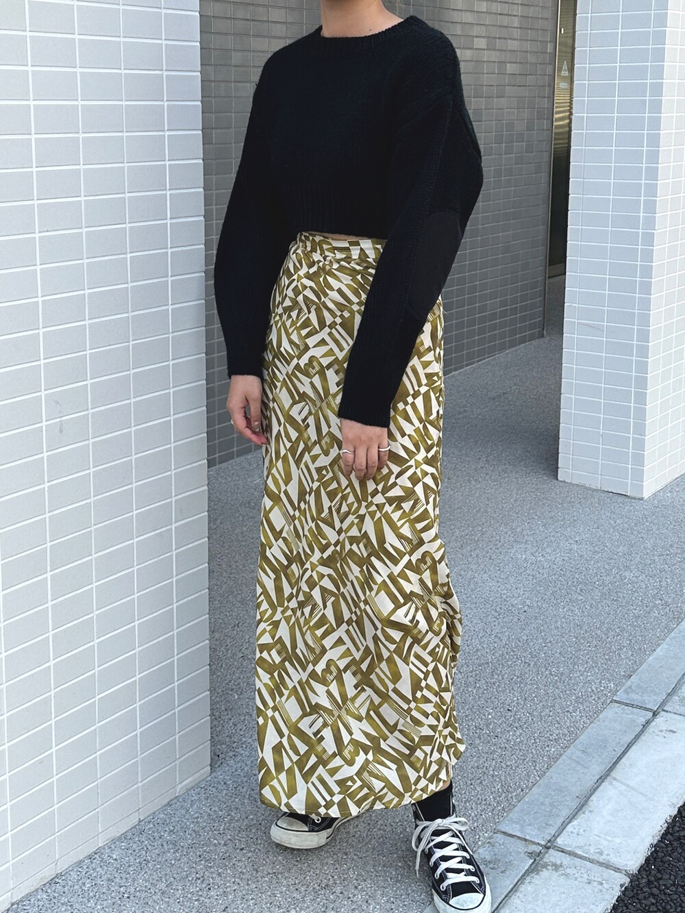 ブラック系のニット/セーターを着用したレディースの秋コーディネートの2枚目の写真