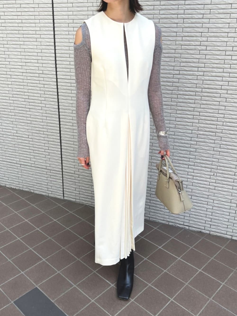 ホワイト系のジャンパースカートを着用したレディースの秋コーディネートの3枚目の写真