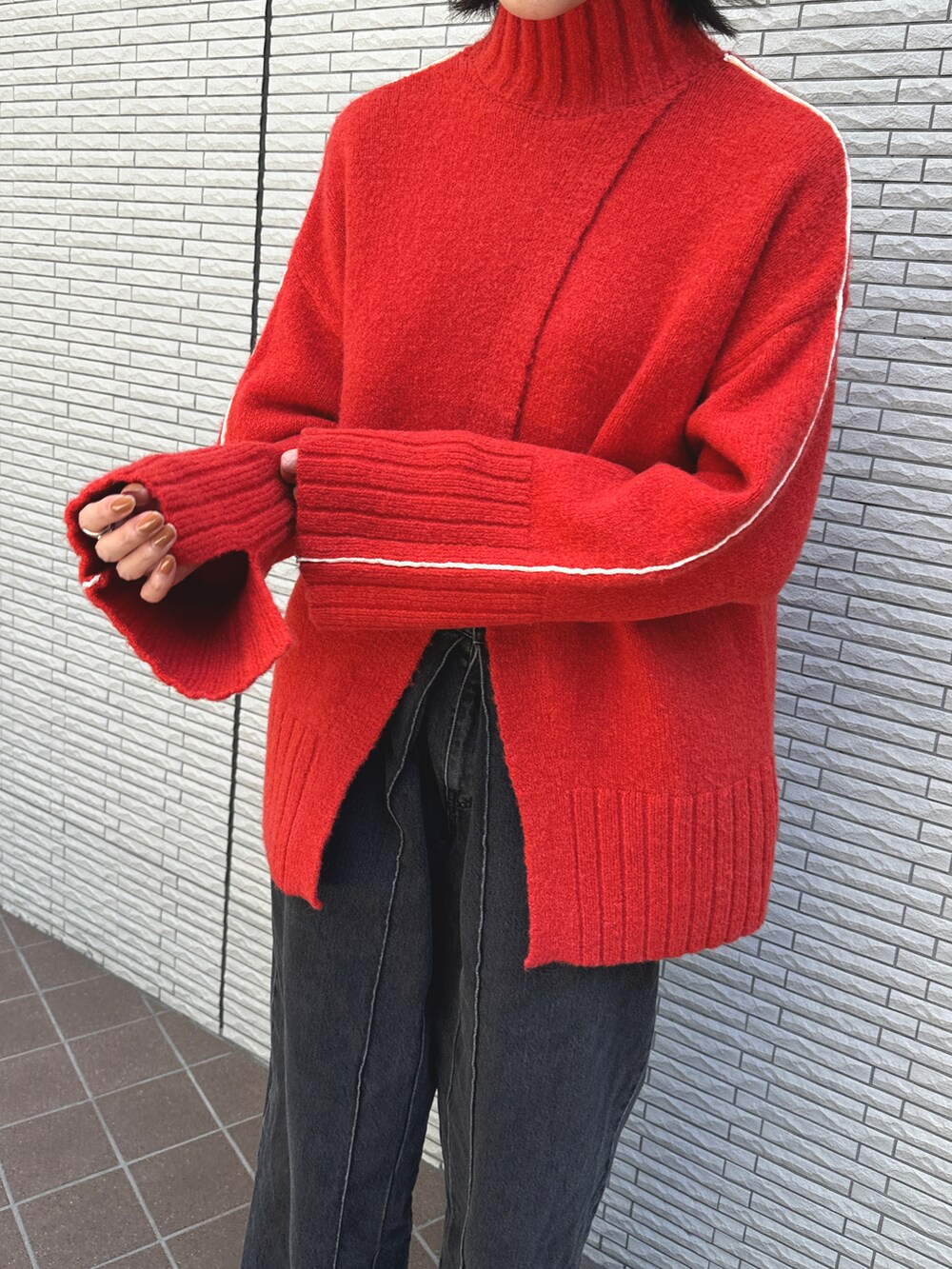 オレンジ系のニット/セーターを着用したレディースの秋コーディネートの3枚目の写真