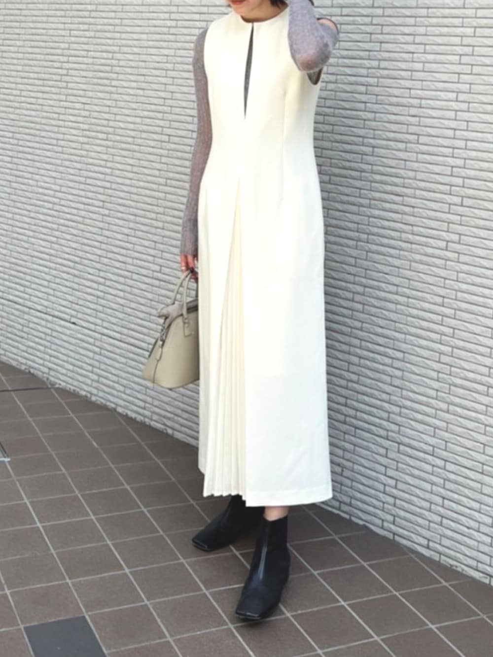 ホワイト系のジャンパースカートを着用したレディースの秋コーディネートの2枚目の写真