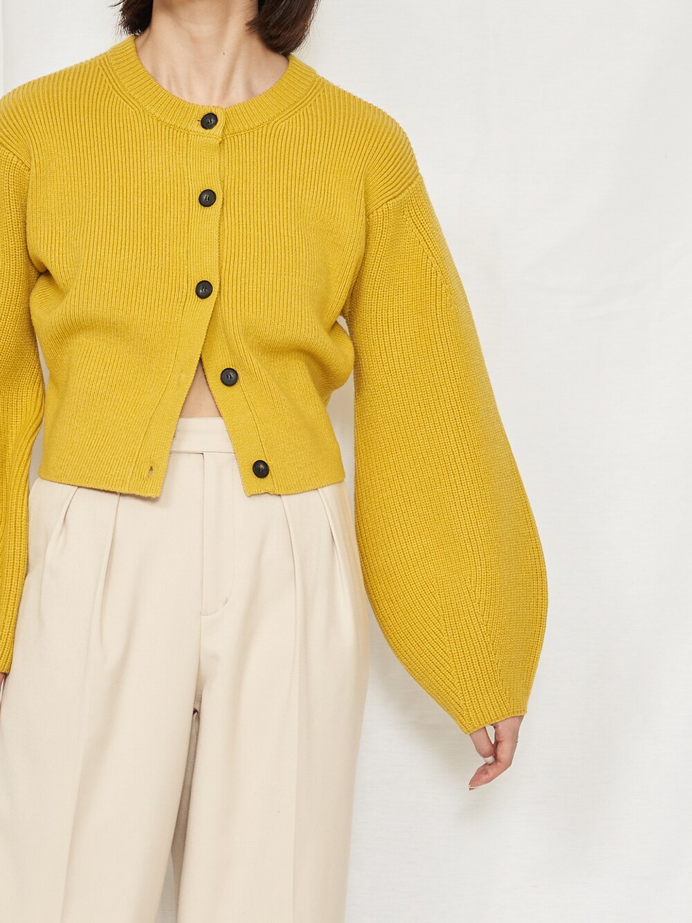 ブラック系のスラックス、イエロー系のカーディガン/ボレロを着用したレディースの秋コーディネートの4枚目の写真