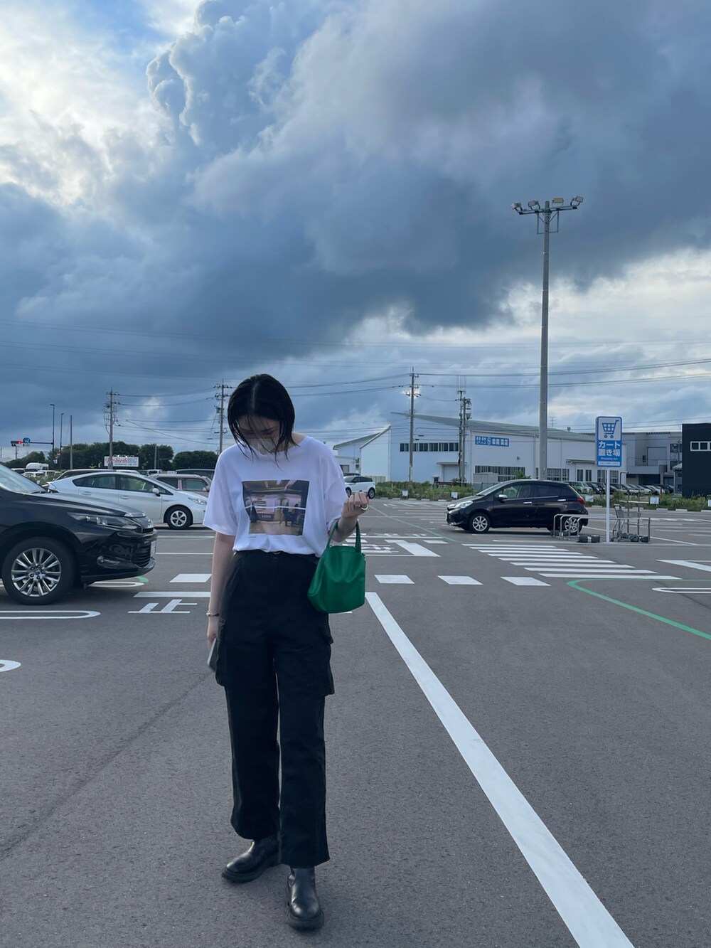 ホワイト系のトップス、ブラック系のブーツを着用したレディースの夏コーディネートの2枚目の写真