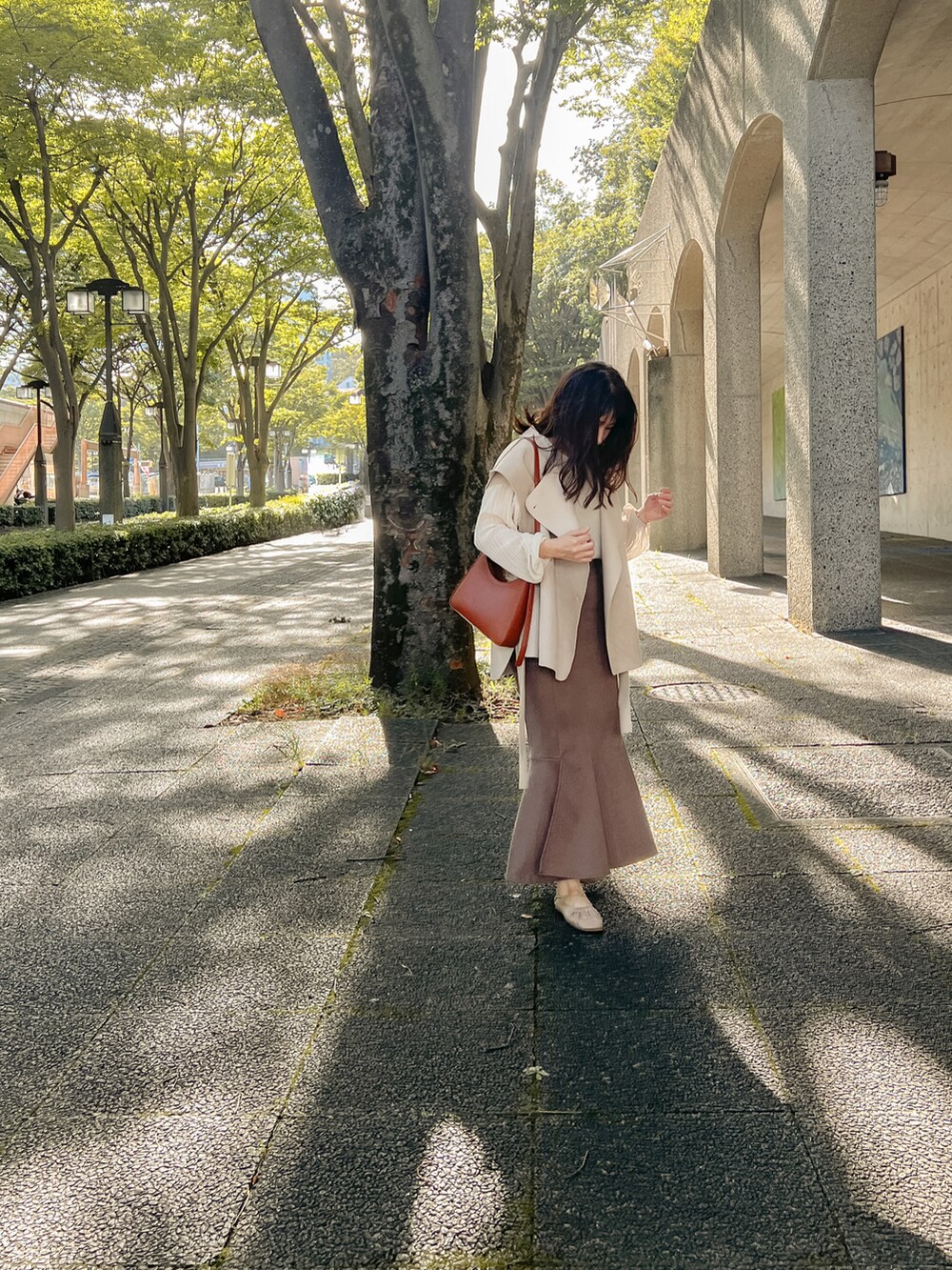 ホワイト系のシャツ/ブラウス、ベージュ系のベスト、ブラウン系のスカートを着用したレディースの秋コーディネートの3枚目の写真