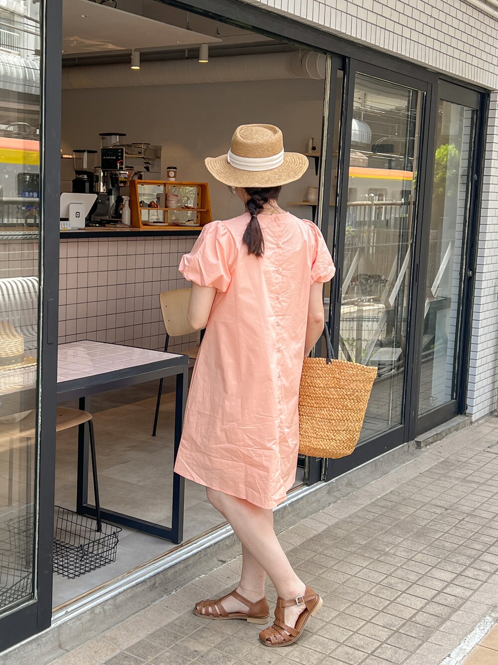 オレンジ系のワンピースを着用したレディースの春コーディネートの3枚目の写真