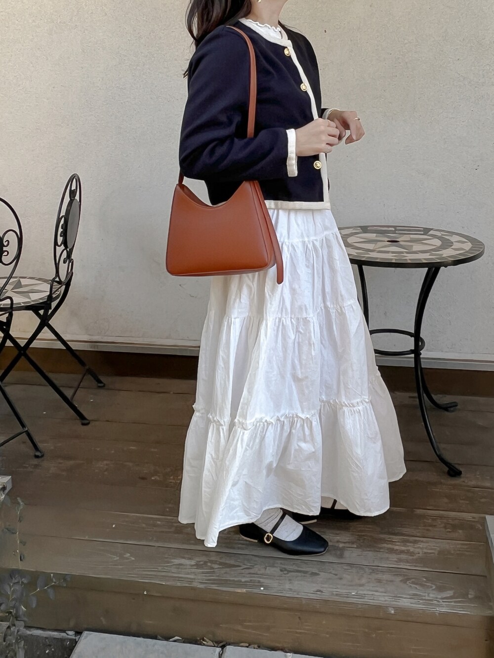 ホワイト系のスカート、ブルー系のノーカラージャケットを着用したレディースの秋コーディネートの2枚目の写真
