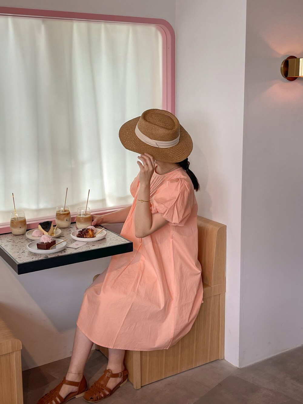 オレンジ系のワンピースを着用したレディースの春コーディネートの2枚目の写真