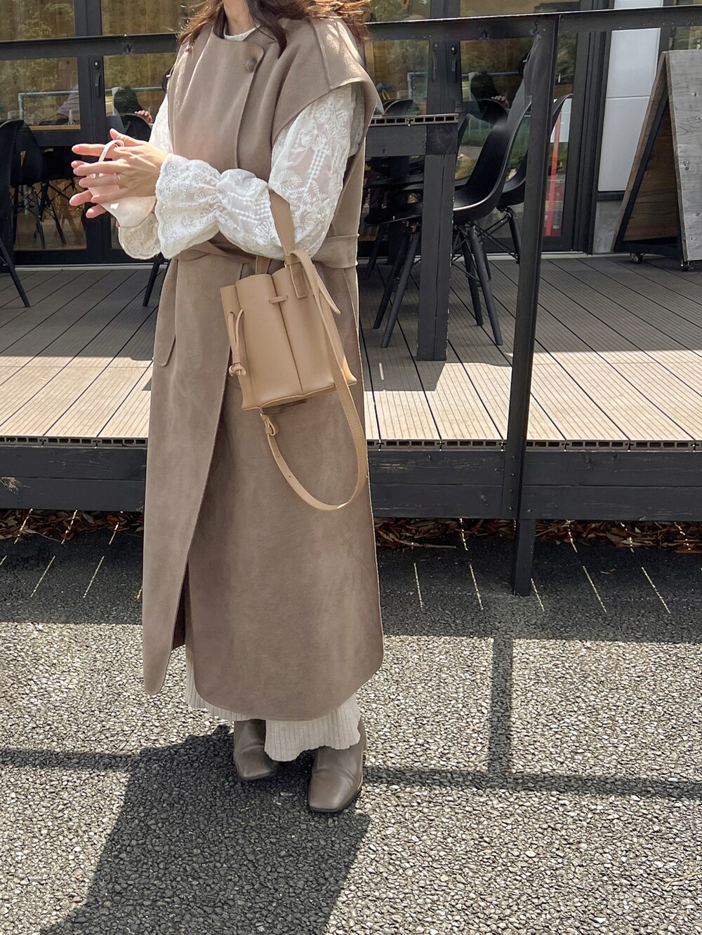 ベージュ系のバッグ、ベージュ系のベストを着用したレディースの秋コーディネートの3枚目の写真