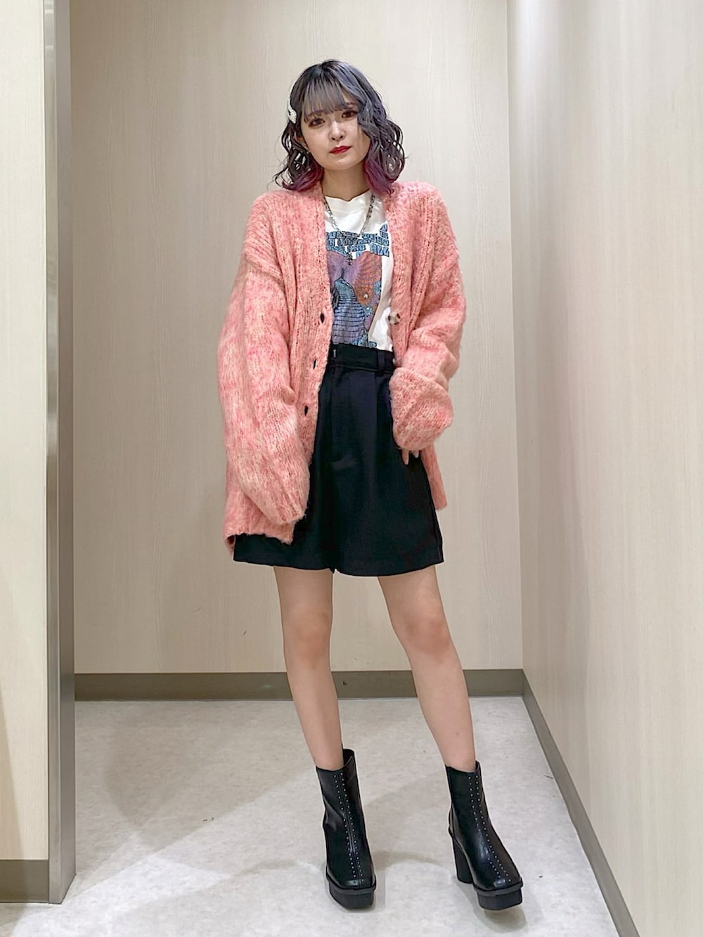 ピンク系のカーディガン/ボレロ、ブラック系のその他パンツ、ブラック系のブーツを着用したレディースの冬コーディネートの2枚目の写真