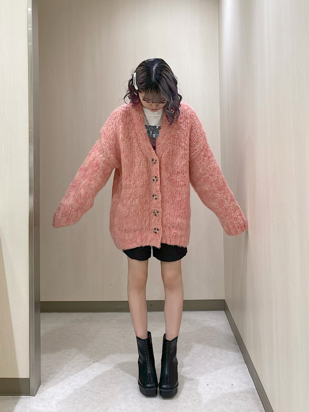 ピンク系のカーディガン/ボレロ、ブラック系のその他パンツ、ブラック系のブーツを着用したレディースの冬コーディネートの3枚目の写真