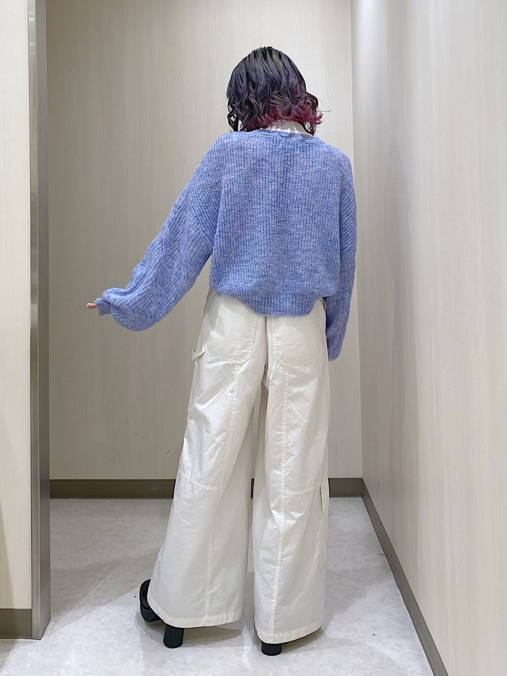 ホワイト系のその他パンツ、ブラック系のブーツ、ブルー系のニット/セーターを着用したレディースの冬コーディネートの2枚目の写真