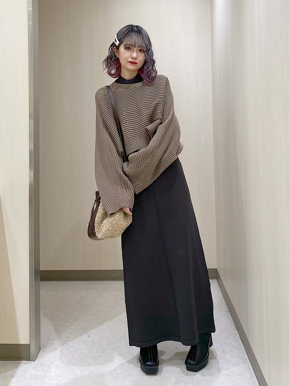 グレー系のワンピース、ベージュ系のショルダーバッグ、ブラック系のブーツを着用したレディースの冬コーディネートの2枚目の写真