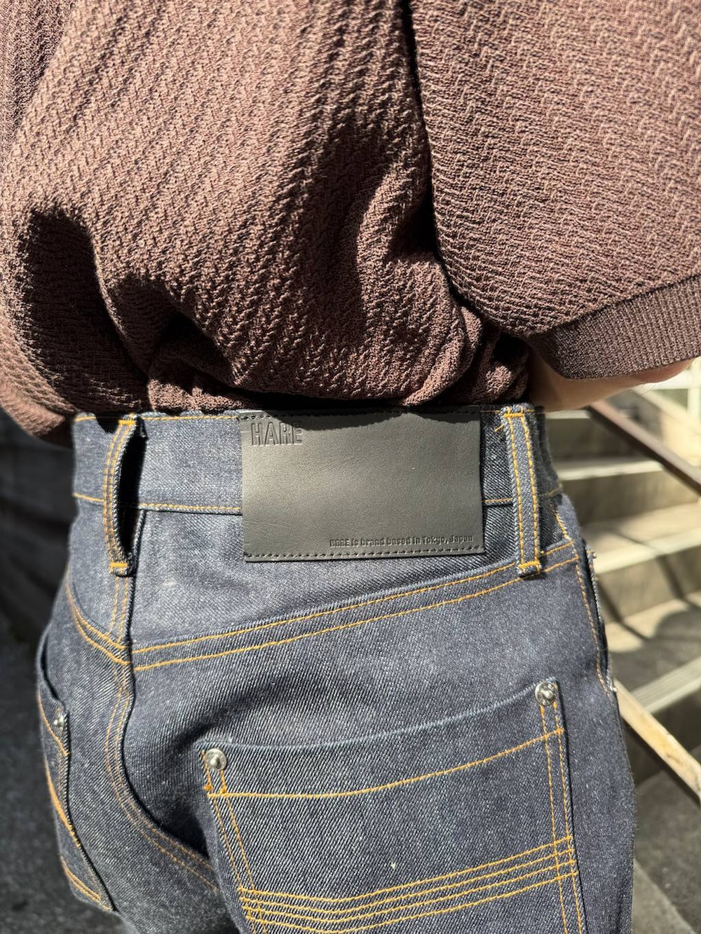 グレー系のタンクトップ、ブラック系のショルダーバッグ、ブラウン系のニット/セーターを着用したメンズの春コーディネートの7枚目の写真