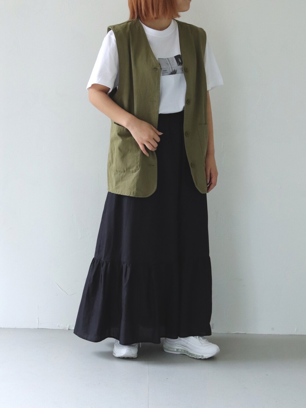 ホワイト系のTシャツ/カットソー、グリーン系のベスト、ホワイト系のスニーカーを着用したレディースの春コーディネートの2枚目の写真