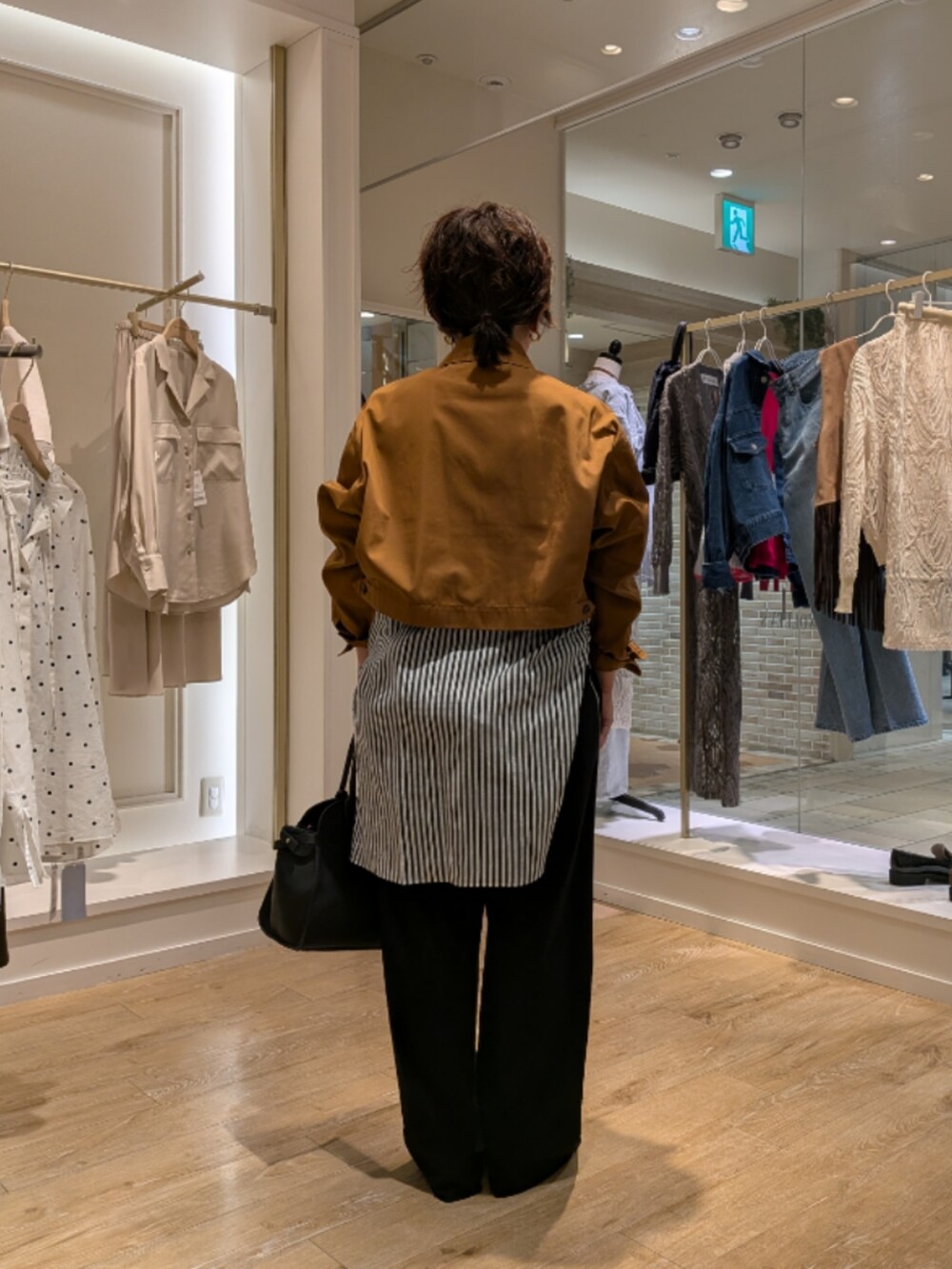 イエロー系のブルゾン、ブルー系のシャツ/ブラウス、ブラック系のその他パンツを着用したレディースの秋コーディネートの4枚目の写真